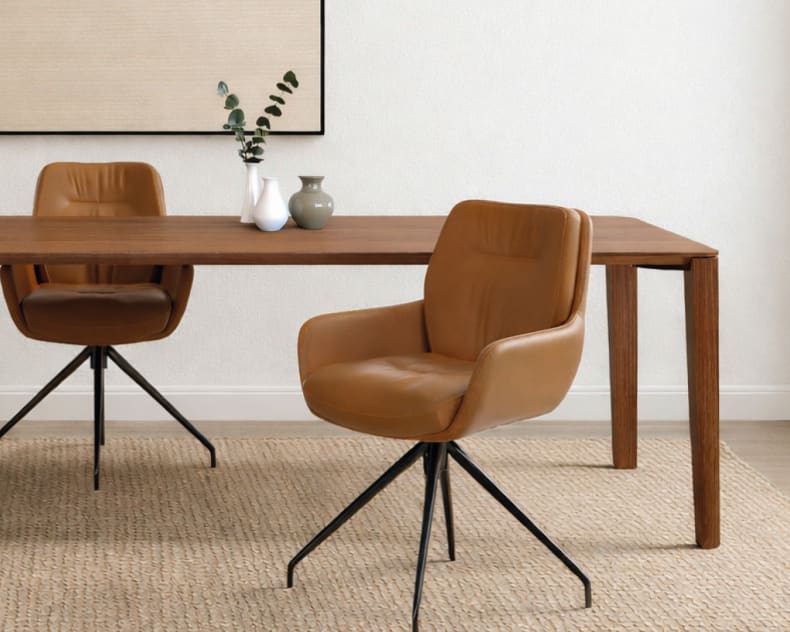 Moderner Essbereich mit zwei Sit Mobilia Stuhl Enna Stühlen, einem Holztisch, dekorativen Vasen, neutraler Wandkunst und einem Webteppich.