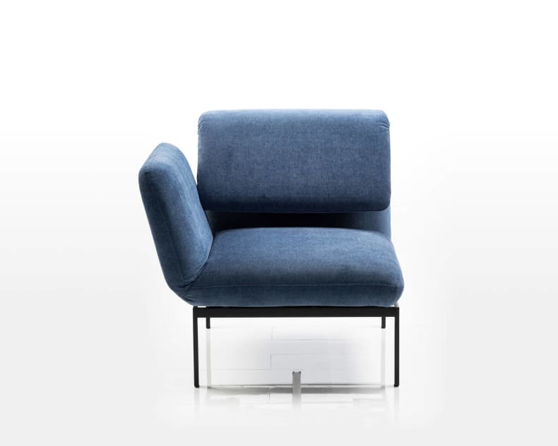 Brühl Roro Small Klassischer blauer gepolsterter armloser Stuhl mit schwarzen Metallbeinen vor einem schlichten weißen Hintergrund.