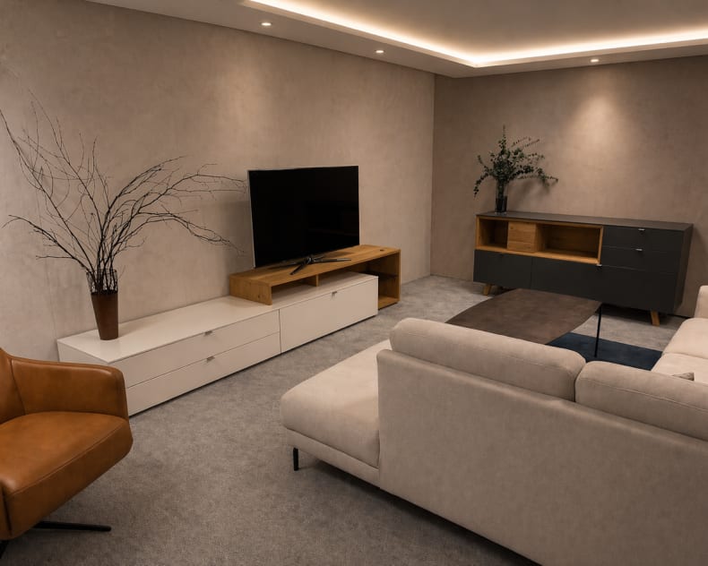 Modernes Wohnzimmer mit einem beigen Sofa, einem Fernseher auf einem Holzständer, einem braunen Sessel, minimalistischem Dekor und dem Venjakob Sideboard Andiamo Home für zusätzlichen Stil und Stauraum.