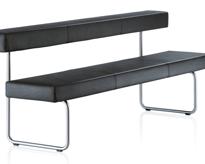 Die Girsberger Sitzbank Permesso ist eine moderne schwarze Lederbank mit Rückenlehne, Metallbeinen und minimalistischem Design, abgebildet auf weissem Hintergrund.