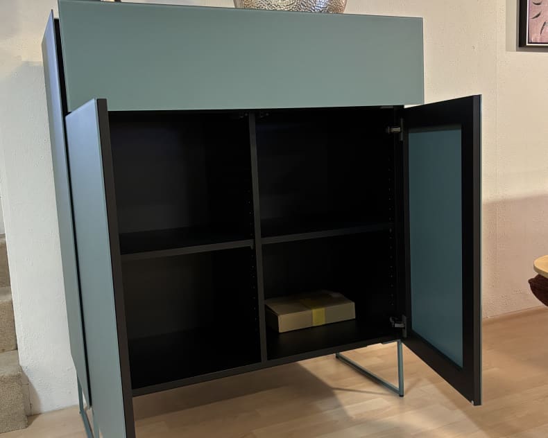 Das Spectral Sideboard 101cm ist ein tealfarbener Schrank mit offenen Türen, Einlegeböden und einer Box im Inneren, die mit einer Lampe und einer Glasschale gekrönt wird.