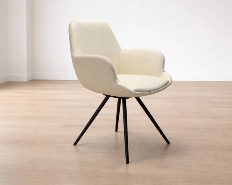 Der Willisau Stuhl Loreo, ein cremefarbener moderner Sessel mit schwarzen Metallbeinen, steht in einem hellen Raum auf einem hellen Holzboden.