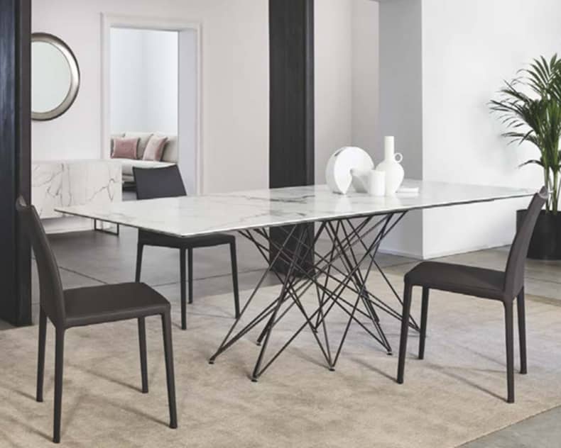 Modernes Esszimmer mit einem Marmortisch, schwarzen Bonaldo Stuhl Kayla Stühlen, Keramikdekor und einer Topfpflanze auf einem beigen Teppich.
