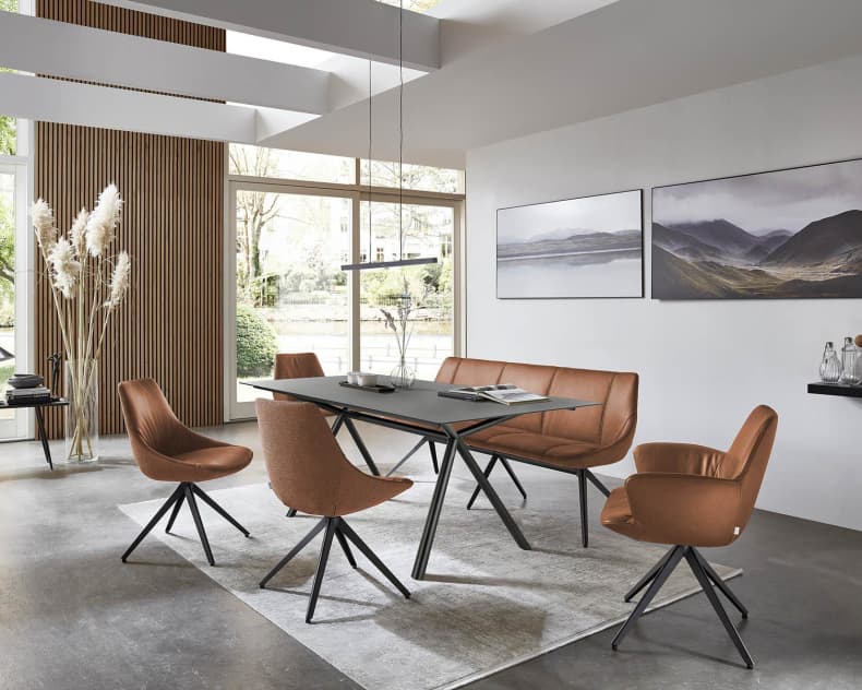 Modernes Esszimmer mit braunen Stühlen von bert plantagie Stuhl Blake Schlitten, einem schwarzen Tisch, großen Fenstern und Wandmalereien im Landschaftsstil.