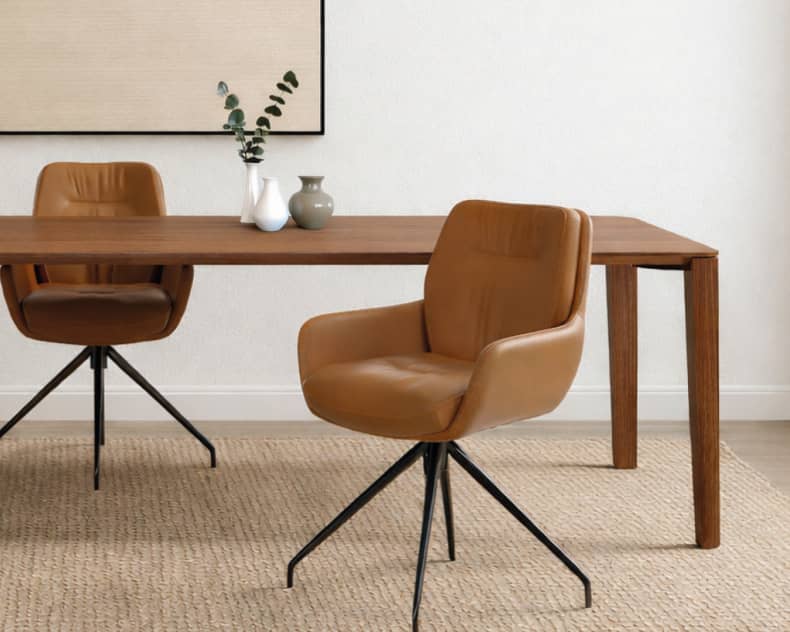 Moderner Essbereich mit zwei Sit Mobilia Stuhl Enna Stühlen, einem Holztisch, dekorativen Vasen, neutraler Wandkunst und einem Webteppich.