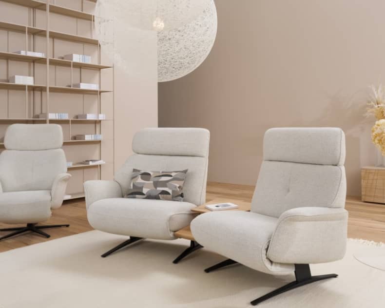 Modernes Wohnzimmer mit drei Himolla Trapezsofa 4362 Lounges, einem eingebauten Bücherregal und einer dekorativen Pendelleuchte.