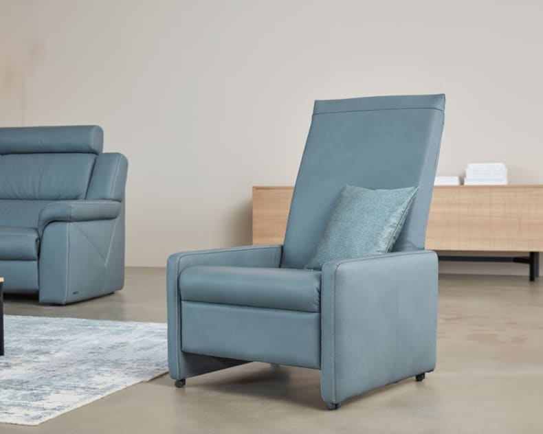 Der Himolla Einzelhocker/Sessel 7112 mit dekorativem Kissen bringt modernen Stil in ein minimalistisches Wohnzimmer.