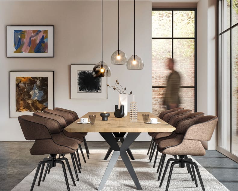 Modernes Esszimmer mit einem Holztisch, acht Voglauer Stuhl 74 in Braun, Pendelleuchten und abstrakter Wandkunst.