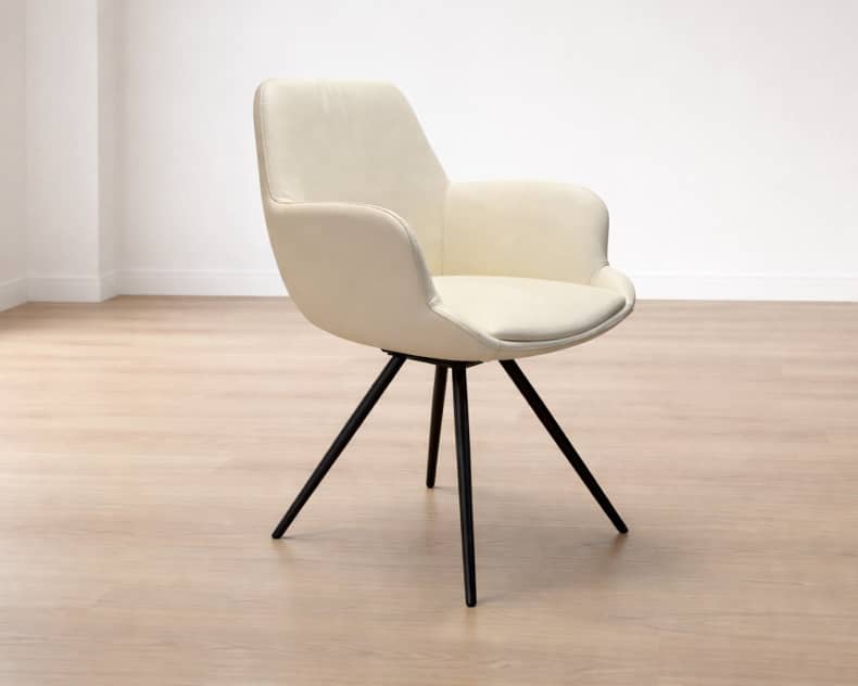 Le fauteuil Willisau Loreo, un fauteuil moderne couleur crème avec des pieds en métal noir, se trouve dans une pièce lumineuse sur un parquet clair.