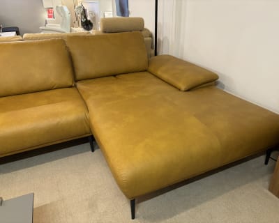 L&#39;ensemble de canapés Samiraa en cuir marron du groupe rembourré possède une large assise sur un tapis beige.