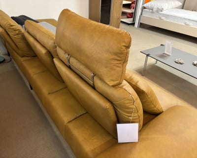 Le groupe capitonné Samiraa, un canapé de relaxation en cuir marron avec appuis-tête réglables, est présenté dans un showroom.