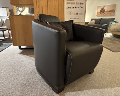 Ein Büromöbel mit 3 Boxen Window in schwarzer Lederausführung mit weißen Nähten, in einem modernen Wohnzimmer.