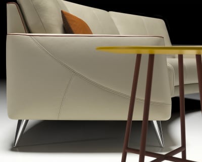 Nahaufnahme des modernen Sofas Thalia 9182 in Beige mit Metallbeinen und einem orangefarbenen Kissen, platziert neben einem gelben Tisch.