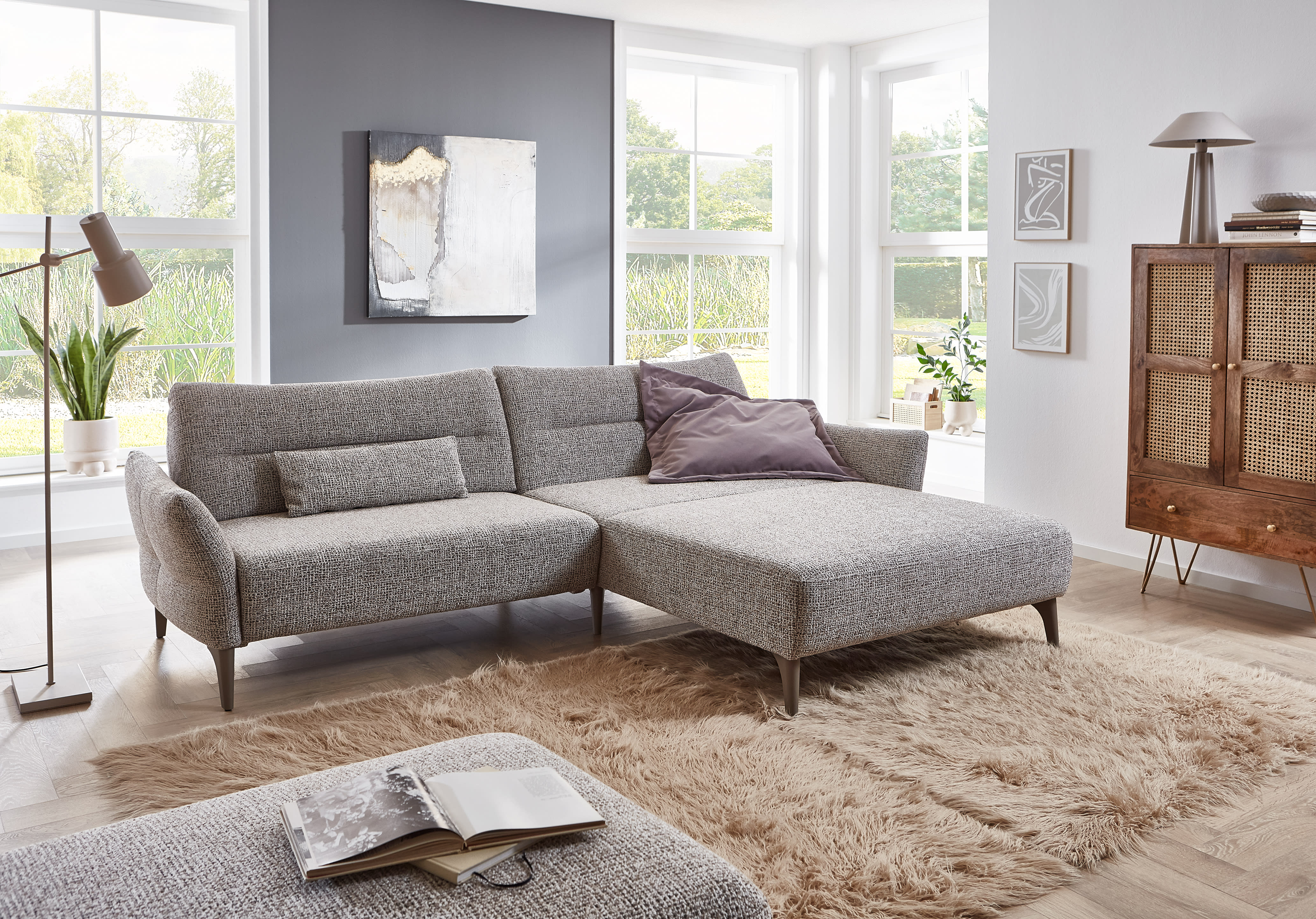 Modernes Wohnzimmer mit dem Ponsel Sofa Paula, einem stilvollen grauen Sektionssofa, gepaart mit einem weichen Teppich, großen Fenstern und elegantem Dekor. Modernes Wohnzimmer mit dem Ponsel Sofa Paula, einem stilvollen grauen Sektionssofa, gepaart mit einem weichen Teppich, großen Fenstern und elegantem Dekor.