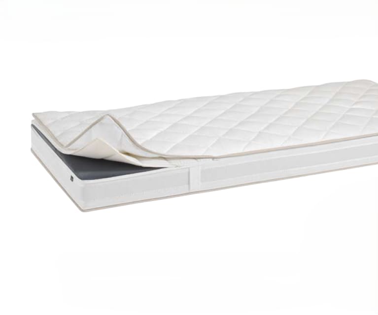 Die Riposa Matratze Grandessa Superluxe soft mit weißer gesteppter Matratzenauflage ist teilweise zurückgezogen auf einer passenden Matratze vor weißem Hintergrund.