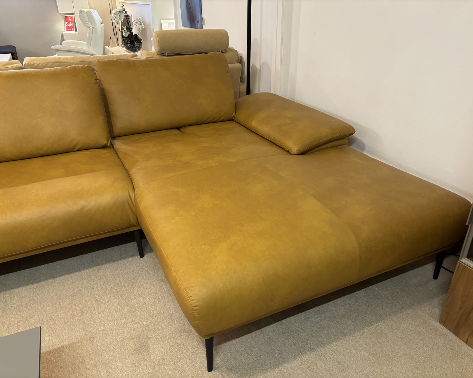 L&#39;ensemble de canapés Samiraa en cuir marron du groupe rembourré possède une large assise sur un tapis beige.