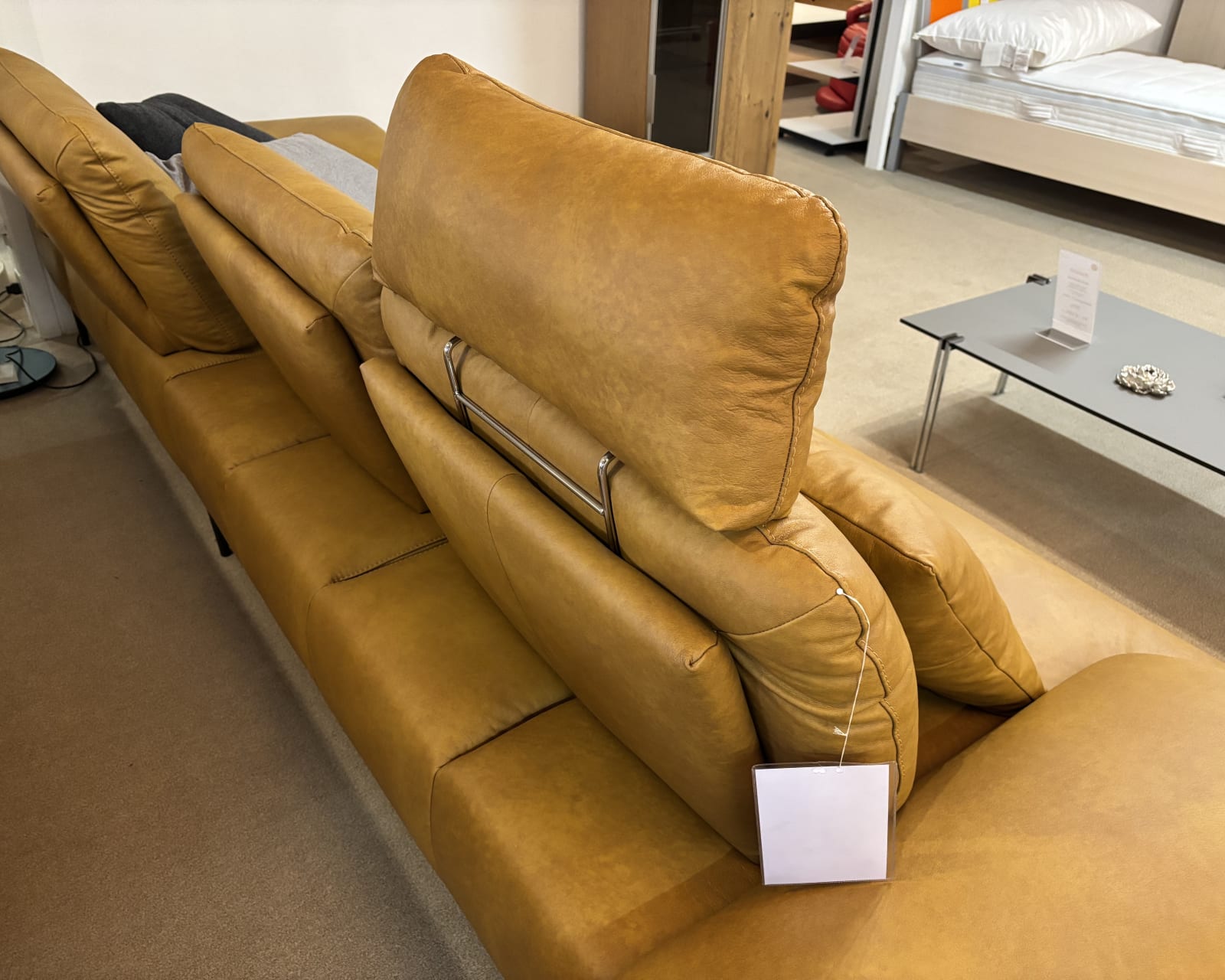 Le groupe capitonné Samiraa, un canapé de relaxation en cuir marron avec appuis-tête réglables, est présenté dans un showroom.
