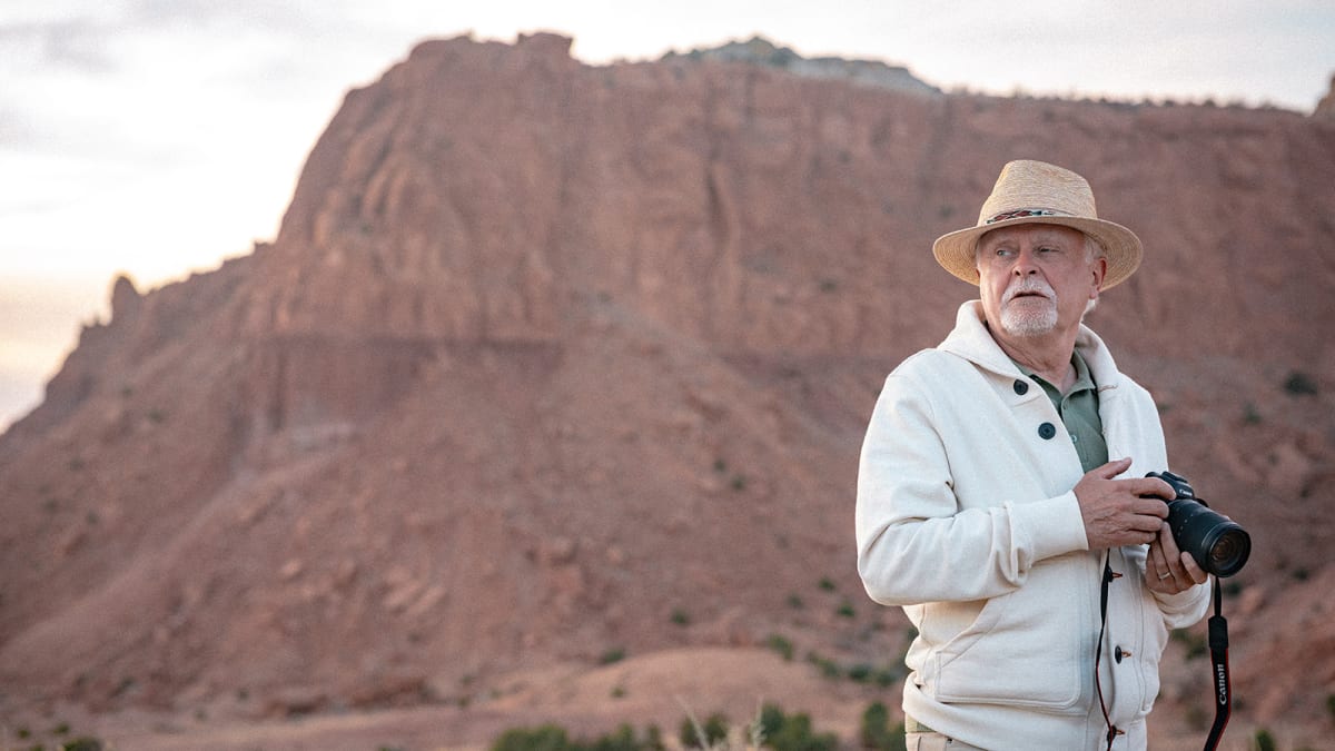 Photographer with a camera at Ghost Ranch red cliffs