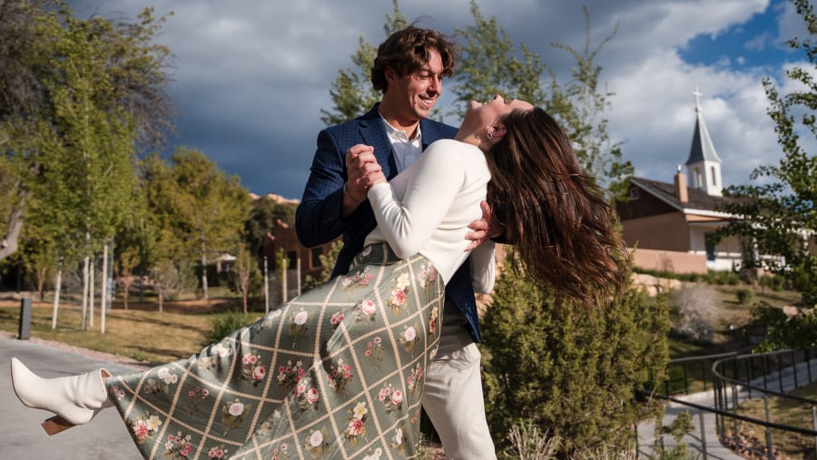 Groom dipping his bride on a hilltop