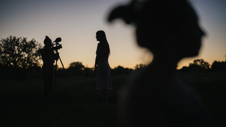 Silhouettes and a camera on sticks at dusk