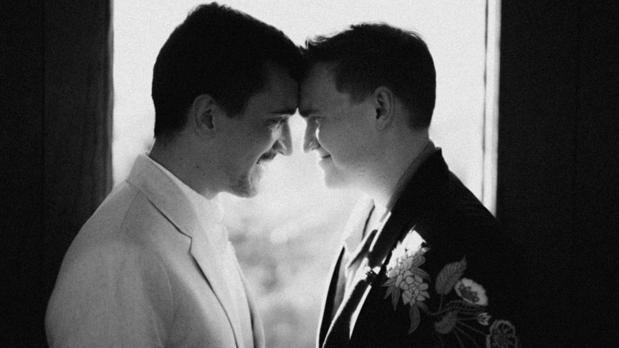 Two grooms forehead to forehead, black and white