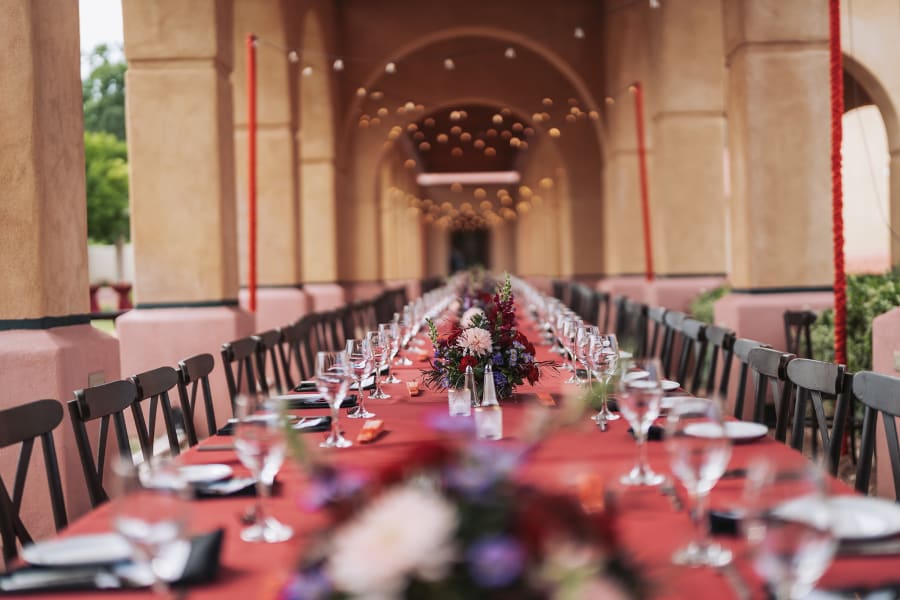 Long dinner table set under an arched portal