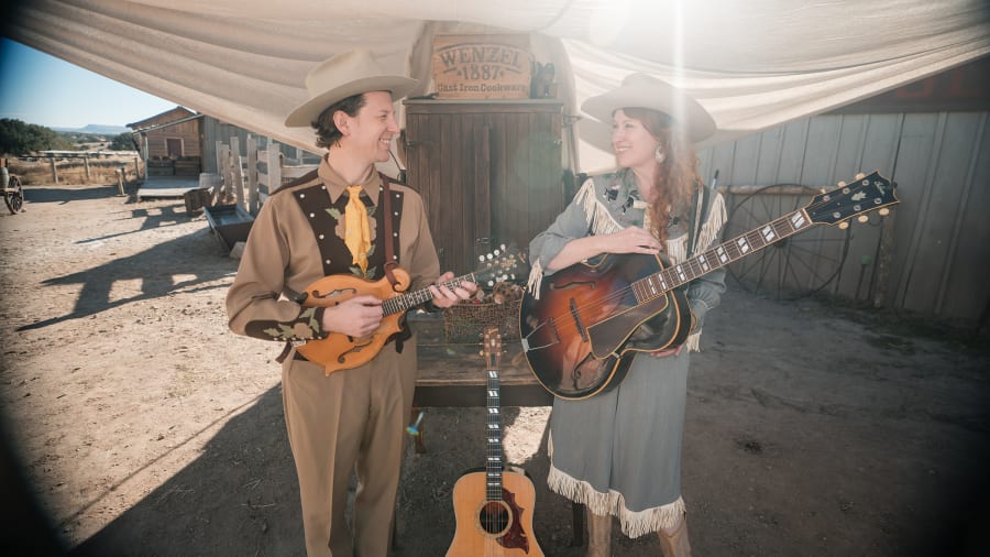 Guitar and mandolin players outside a saloon