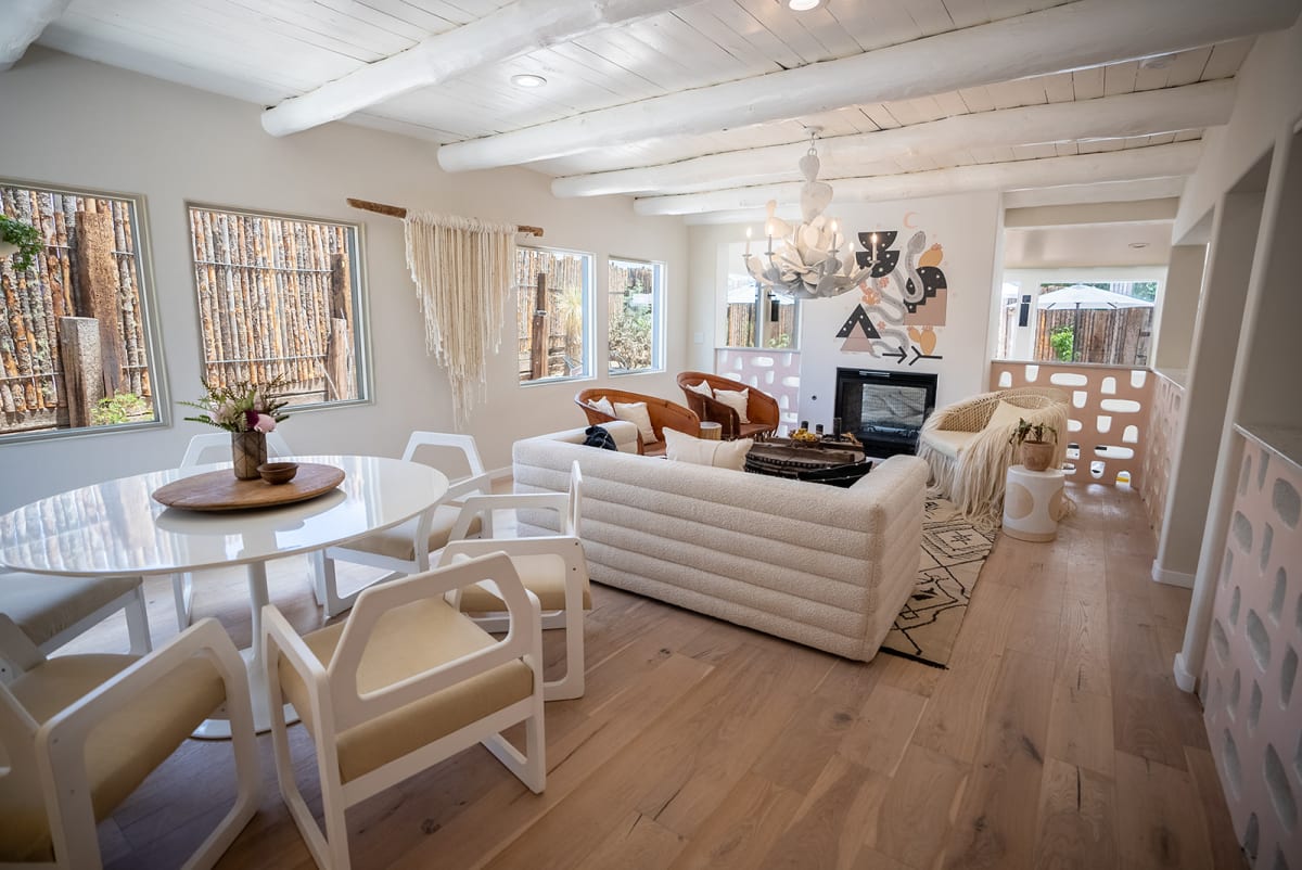 Open-concept living space with exposed beams and floor-to-ceiling windows, Santa Fe — Casey Addason Photography