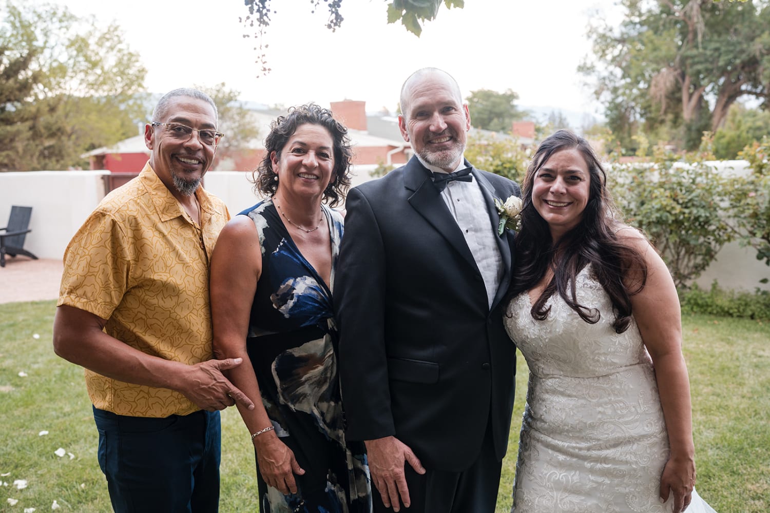 wedding portrait captures four family members posed on manicured grass at what appears to be a So... — Casey Addason Photography