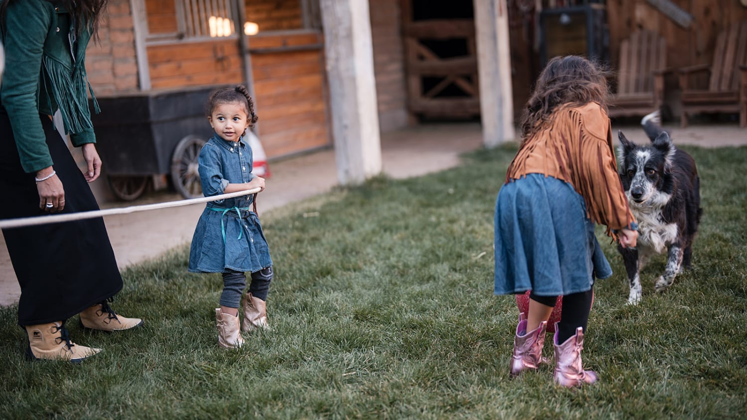 This outdoor portrait photographs a candid family moment at a rural ranch setting, featuring weathered — Casey Addason Photography