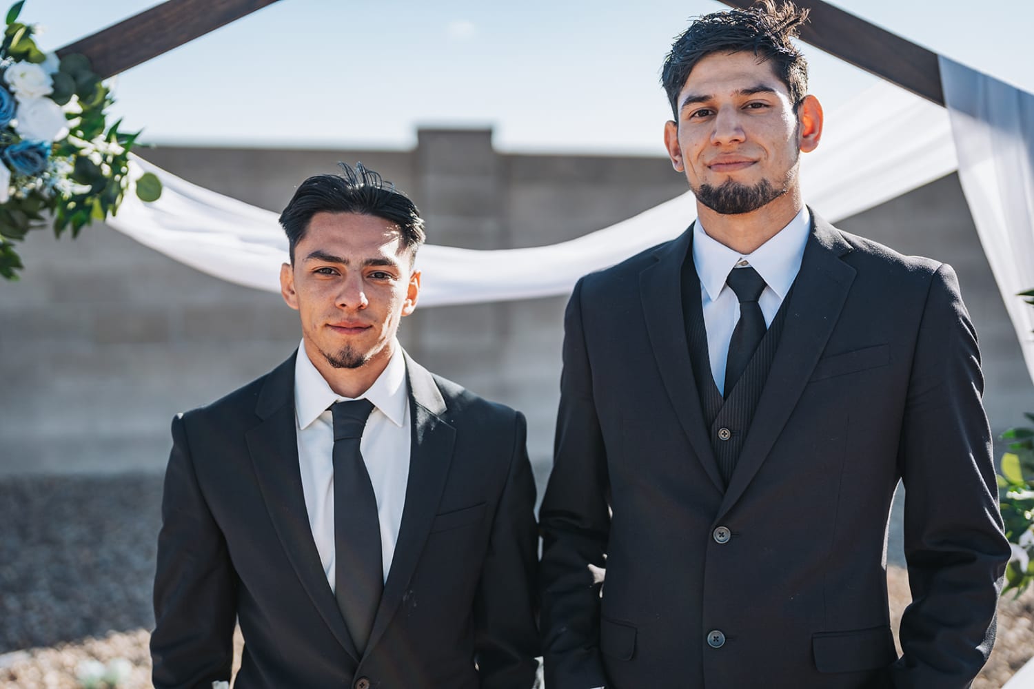 Two grooms under pergola at El Monte Sagrado Taos, New Mexico, outdoor ceremony, Casey Addason Photography