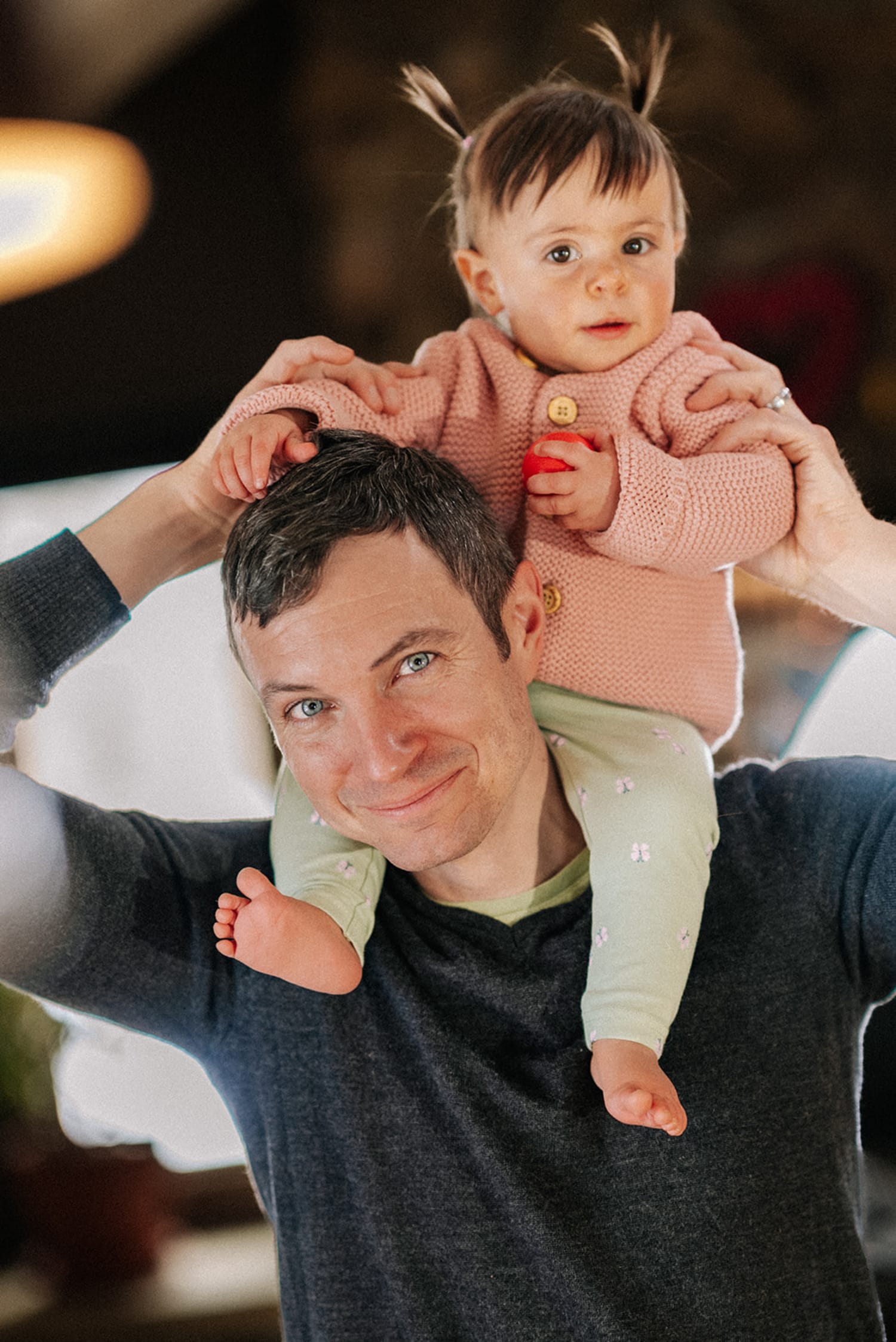 This intimate family portrait photographs a father holding his toddler daughter on his shoulders in an — Casey Addason Photography