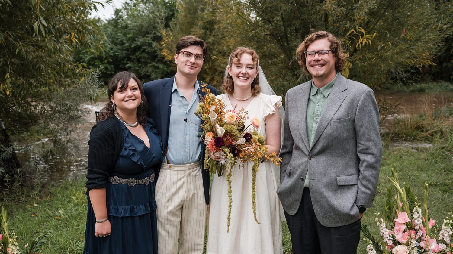 ceremony portrait captures four well-dressed guests posed against a lush, overgrown garden backdr... — Casey Addason Photography