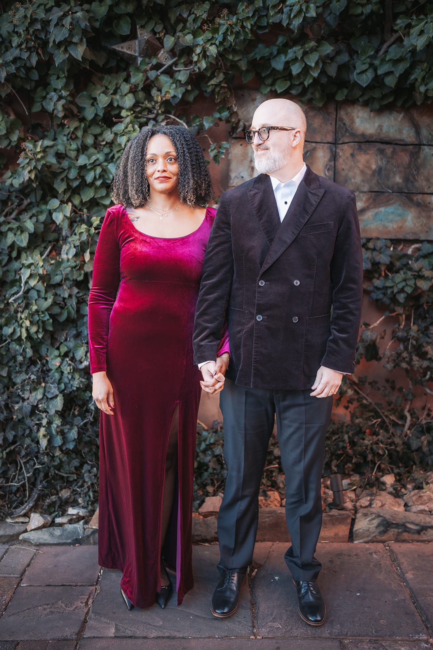 Couple at weathered adobe and ivy wall at Inn of the Five Graces, formal evening attire, urban garden aesthetic, Santa Fe, Casey Addason Photography