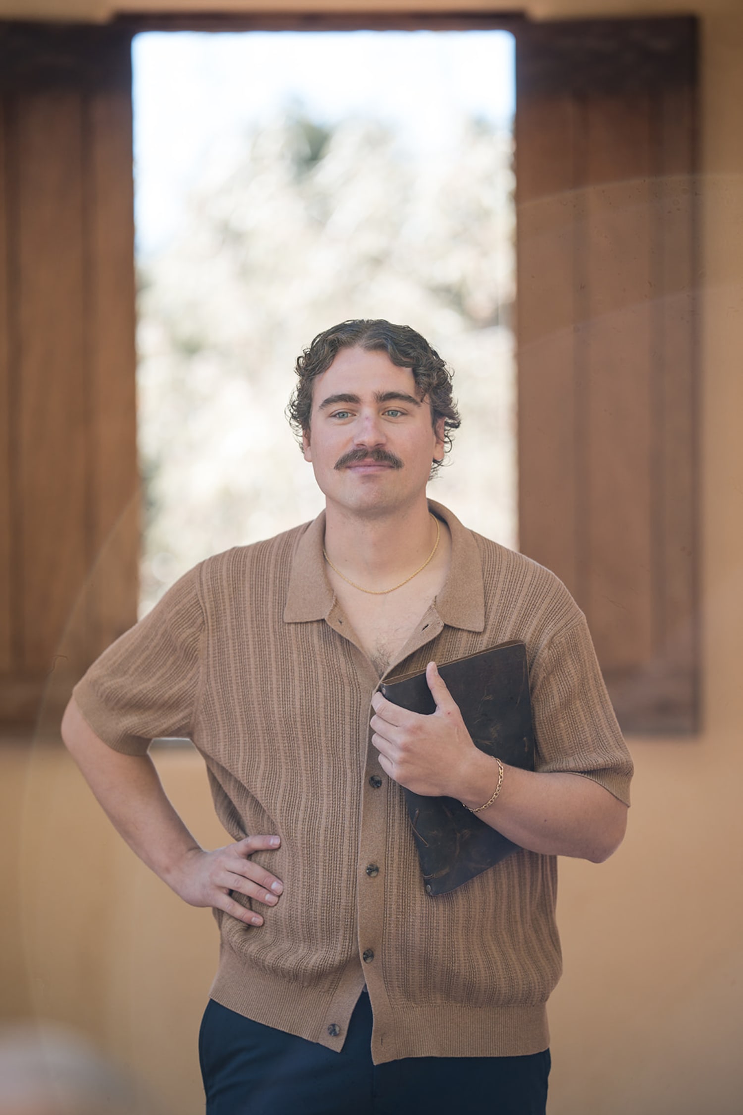 portrait session captures a subject in a beige ribbed cardigan and dark trousers, positioned with... — Casey Addason Photography