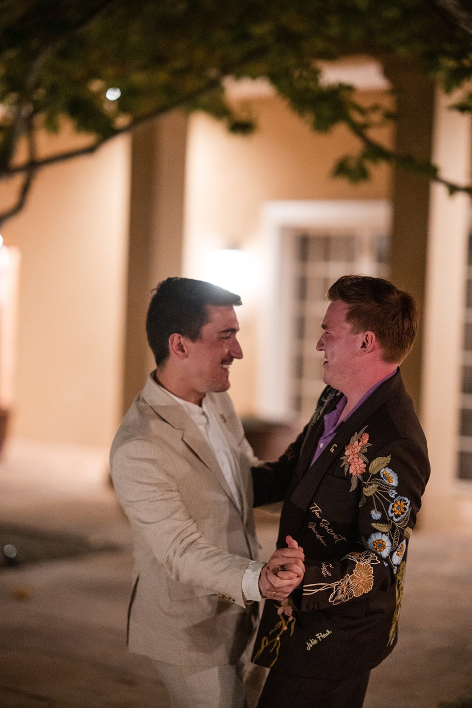 Two men in formal attire—one wearing a cream blazer with purple shirt, the other in an ornate bla... — Casey Addason Photography