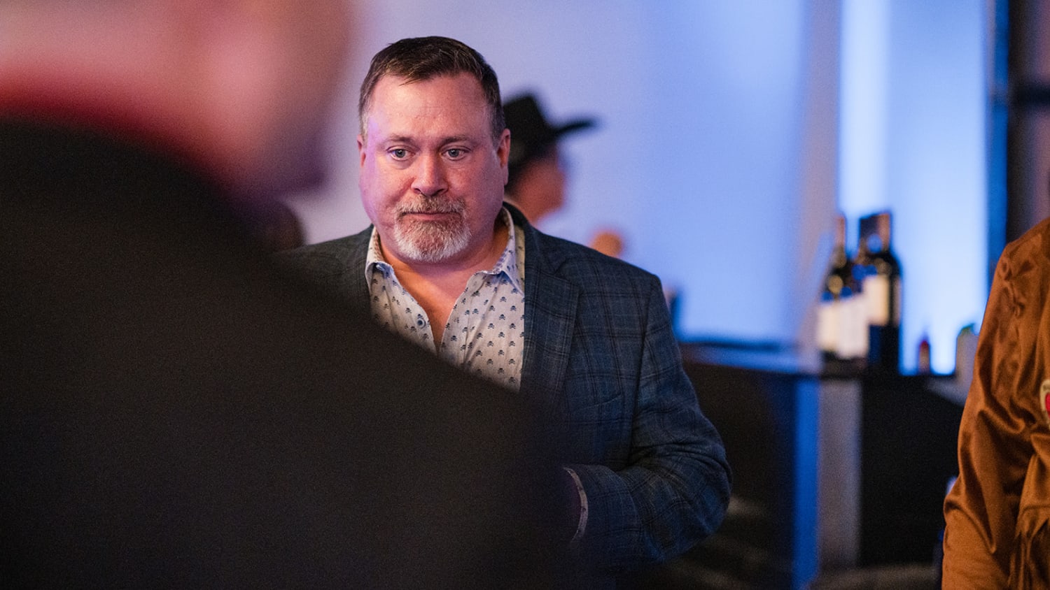 event photograph captures a man in a navy plaid blazer and patterned shirt engaged in conversatio... — Casey Addason Photography