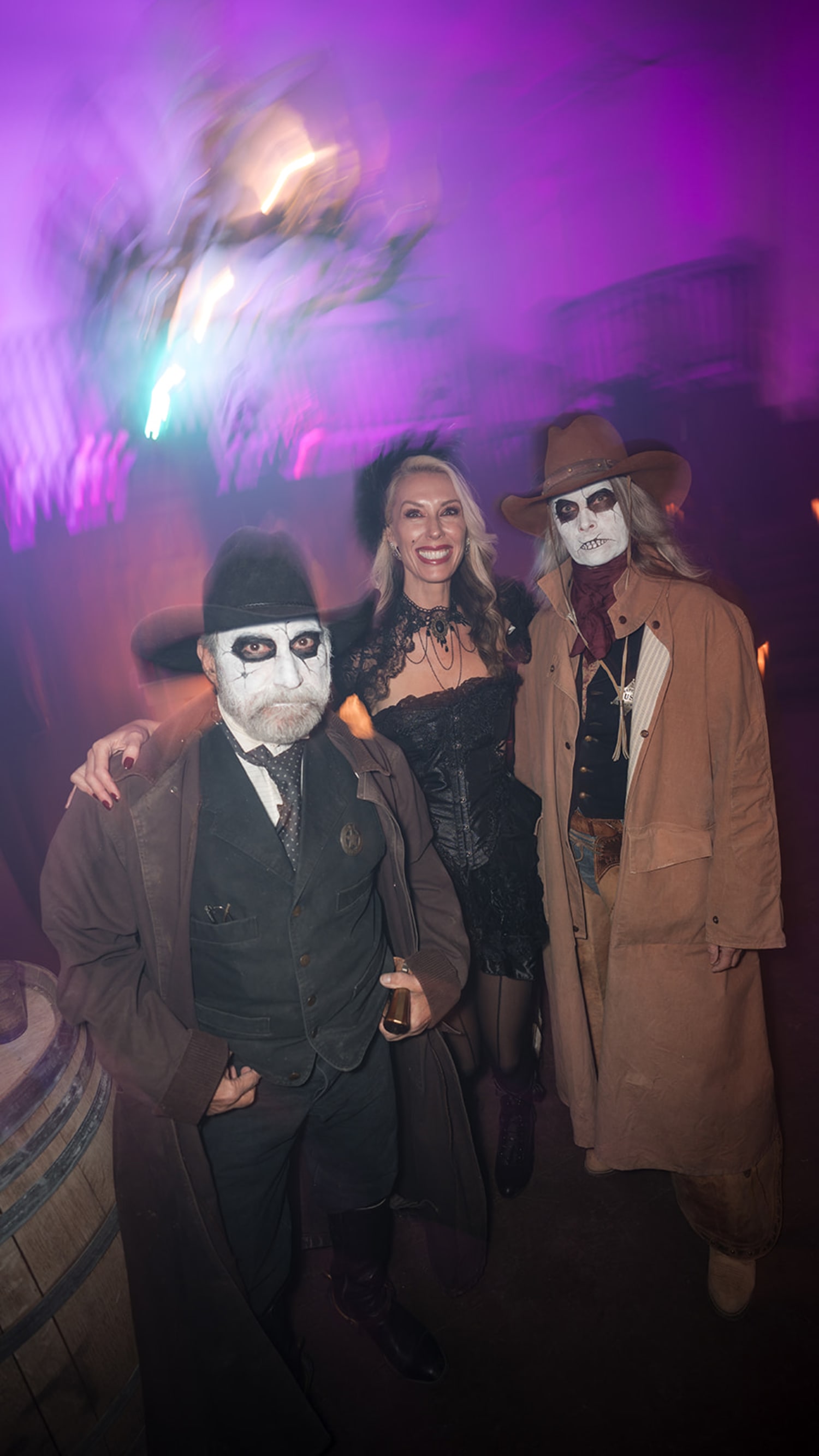 event features three people in elaborate Halloween costumes positioned against a dramatic purple ... — Casey Addason Photography