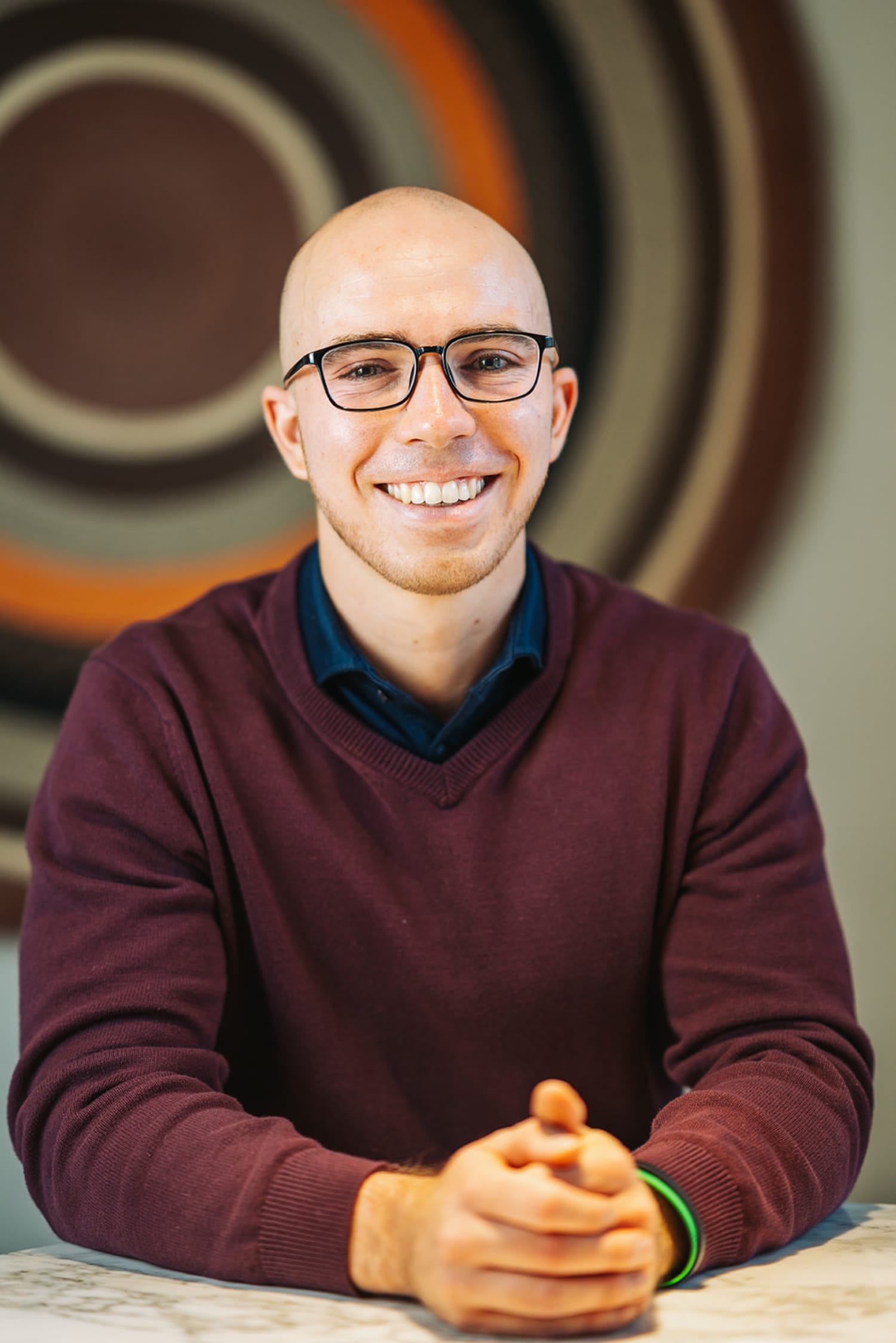 Professional indoor headshot with warm lighting and modern backdrop