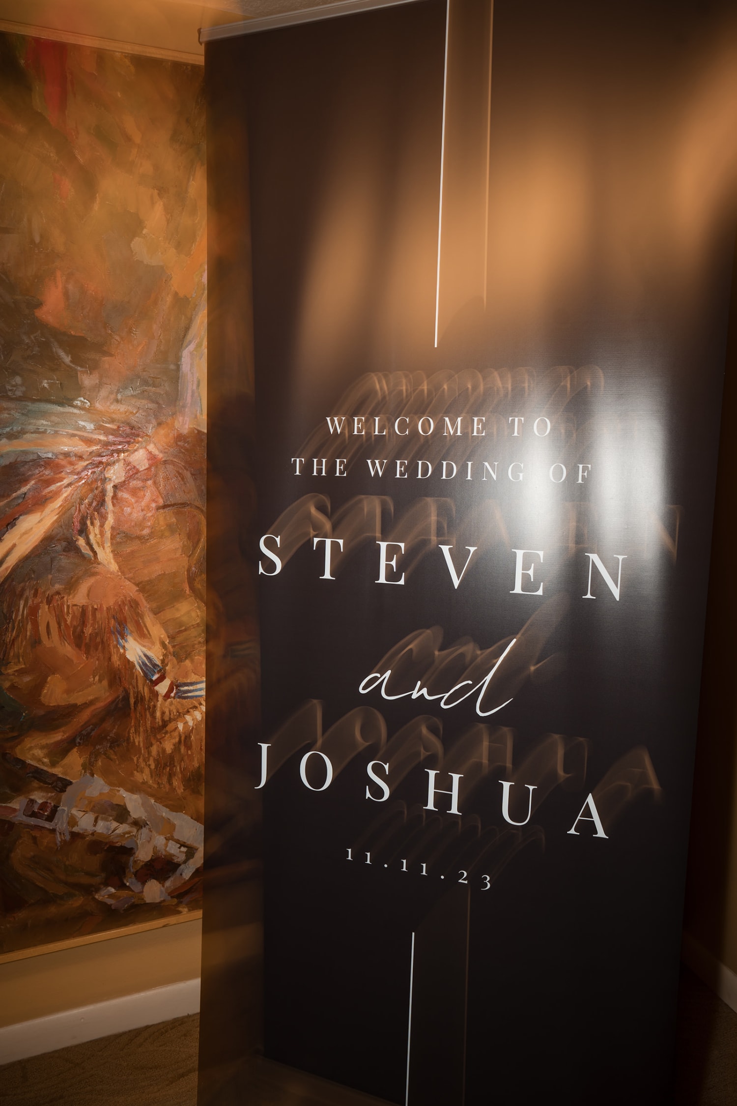 wedding entrance features a modern black welcome sign with elegant white typography announcing th... — Casey Addason