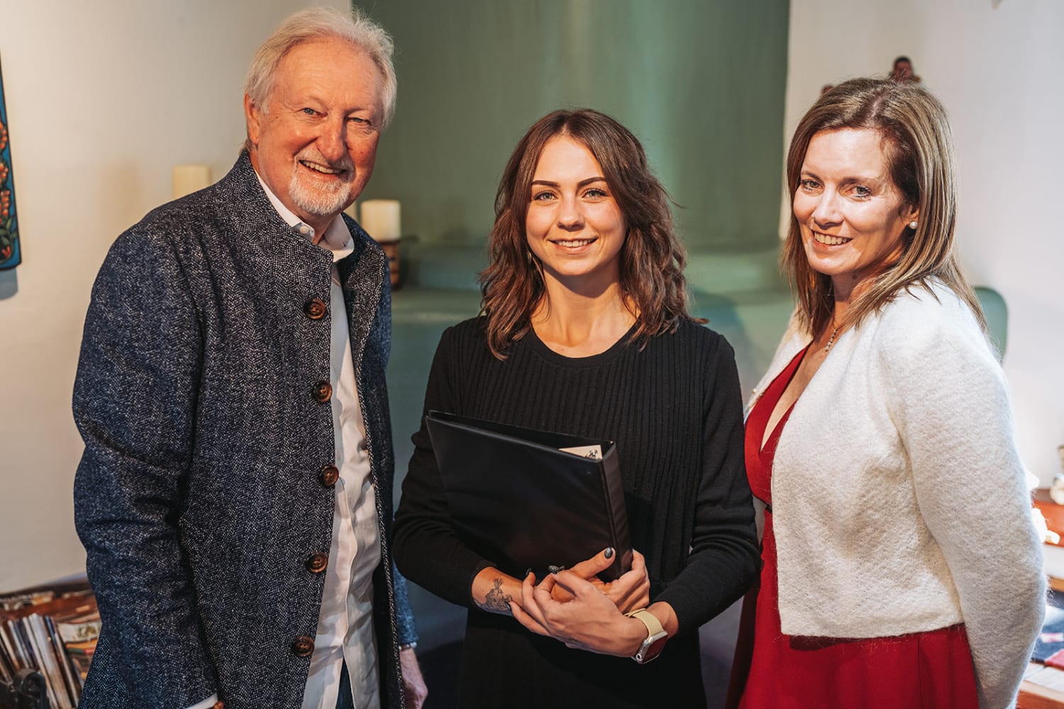 portrait captures three guests at what appears to be a casual gallery or institutional gathering,... — Casey Addason Photography