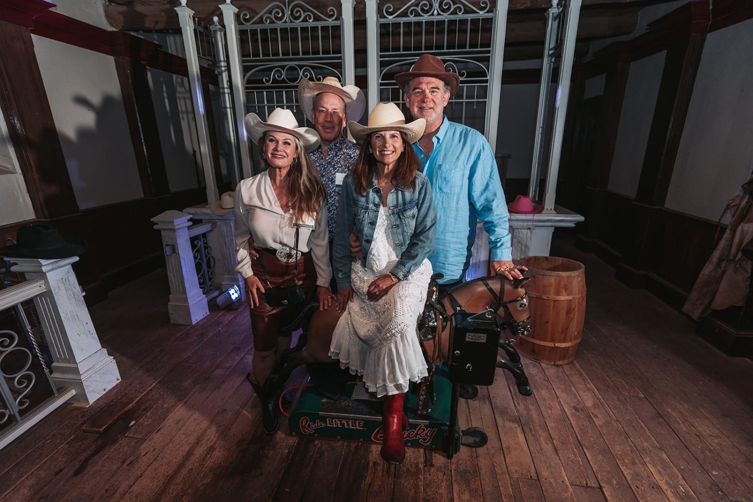 portrait captures four guests in coordinated cowboy attire posed together in what appears to be a... — Casey Addason Photography