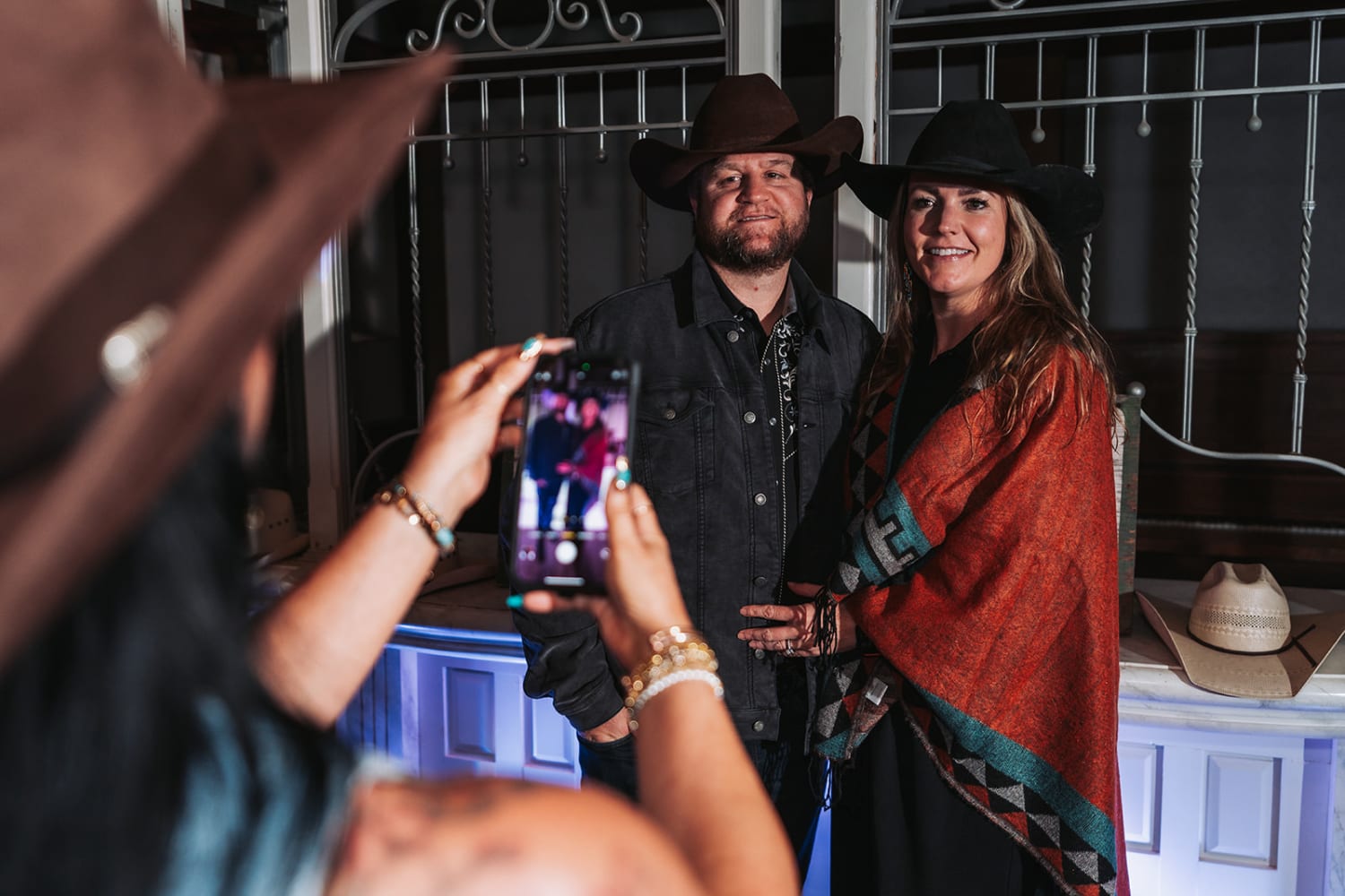 event features a rustic venue with decorative metal stall gates and ornamental ironwork, creating... — Casey Addason Photography