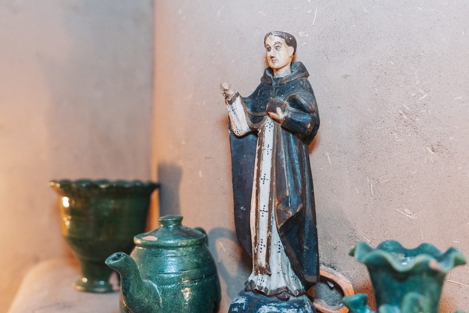 still life captures a traditional religious statue—depicting a robed saint or clergy member in da... — Casey Addason Photography