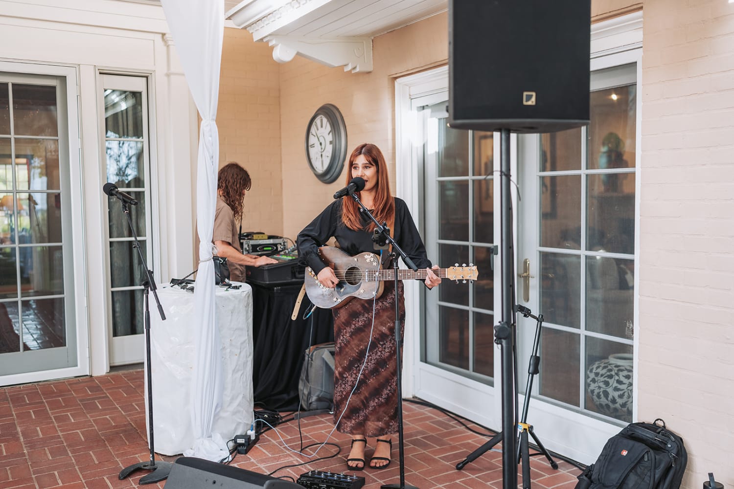 acoustic performance captures a female musician with reddish-brown hair singing and playing guita... — Casey Addason Photography