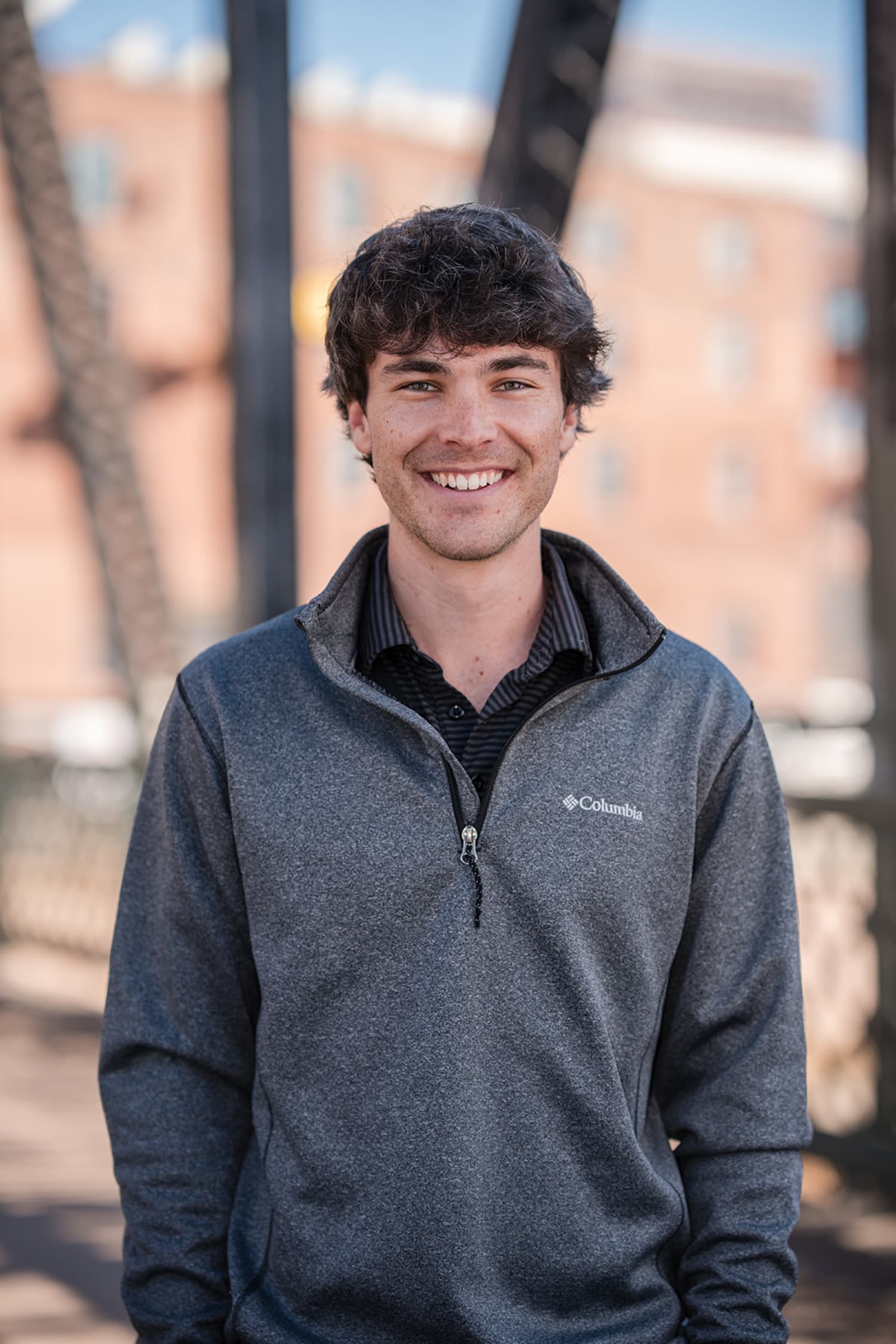 Young man headshot at adobe brick background, Southwest location, professional portrait Santa Fe, Casey Addason Photography