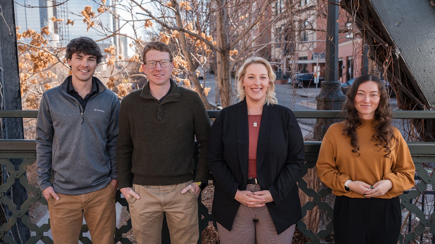 Four-person team portrait on terrace overlooking urban skyline, autumn foliage, golden hour, Santa Fe, Casey Addason Photography