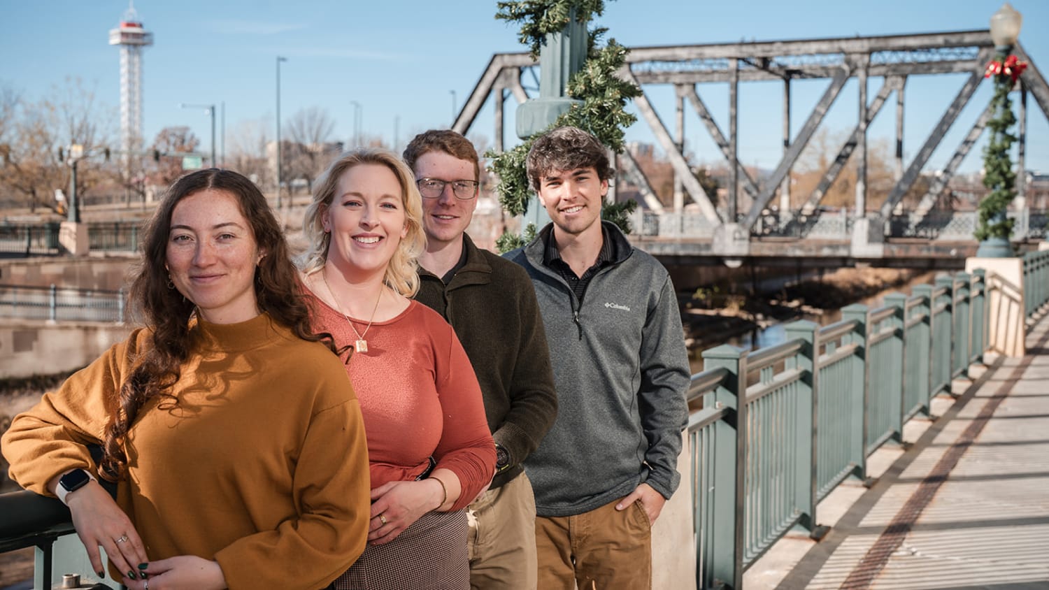 Group portrait on pedestrian bridge with industrial steel truss architecture, lifestyle approach, Santa Fe, Casey Addason Photography