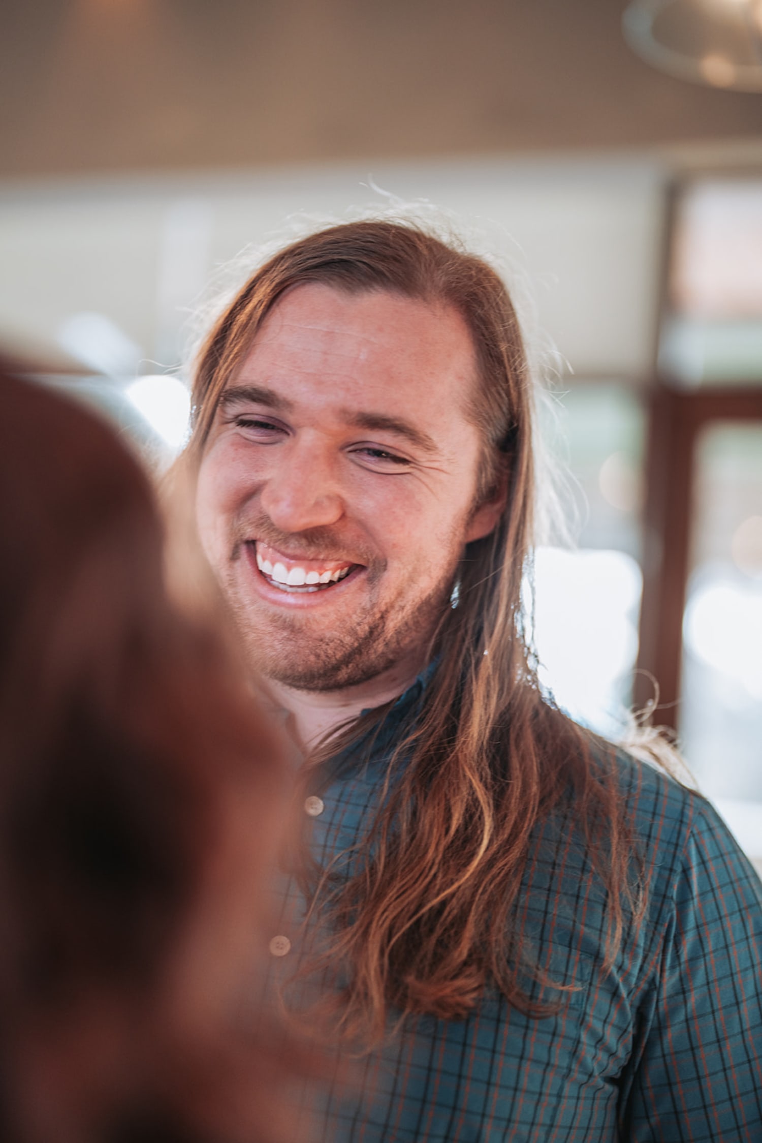is an indoor portrait photograph taken during golden hour, with warm, diffused natural light stre... — Casey Addason Photography
