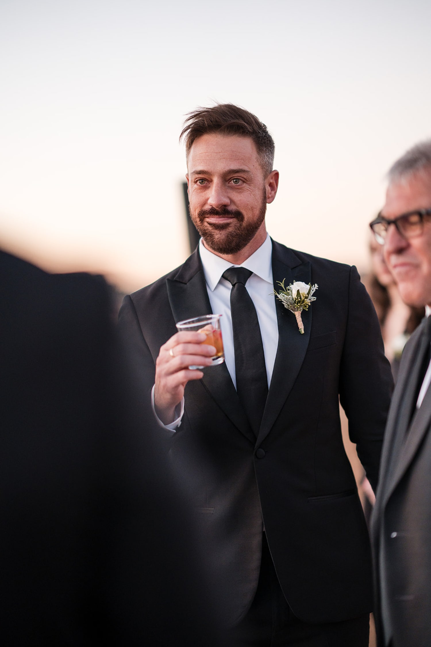 reception photograph documents a groom in formal black-tie attire—black suit, white dress shirt, b... — Casey Addason Photography